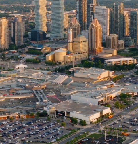 Expansive city skyline highlighting a major shopping centre within a dense and active urban setting