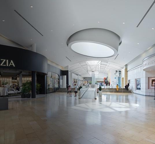 Open mall walkway with wide space and visitors moving comfortably through the interior area