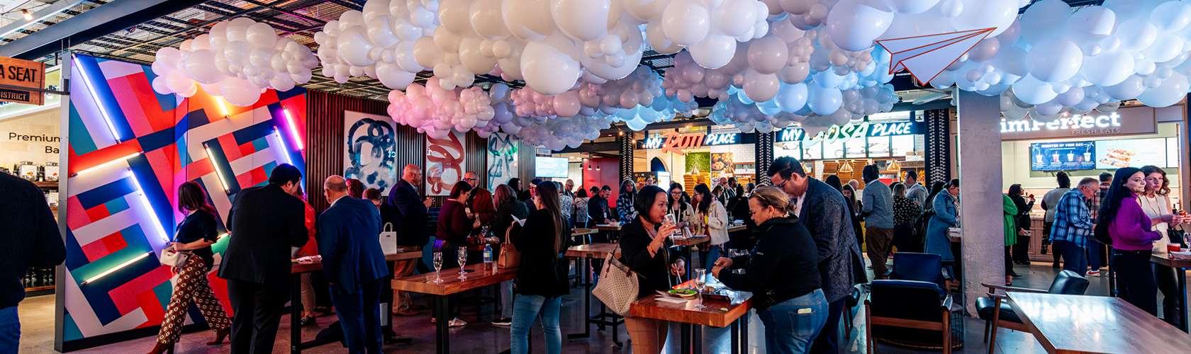 Guests enjoying a business event at the Food District with dining and social gathering spaces