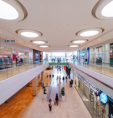 Two-level mall interior with Claire's and Old Navy and round ceiling lights