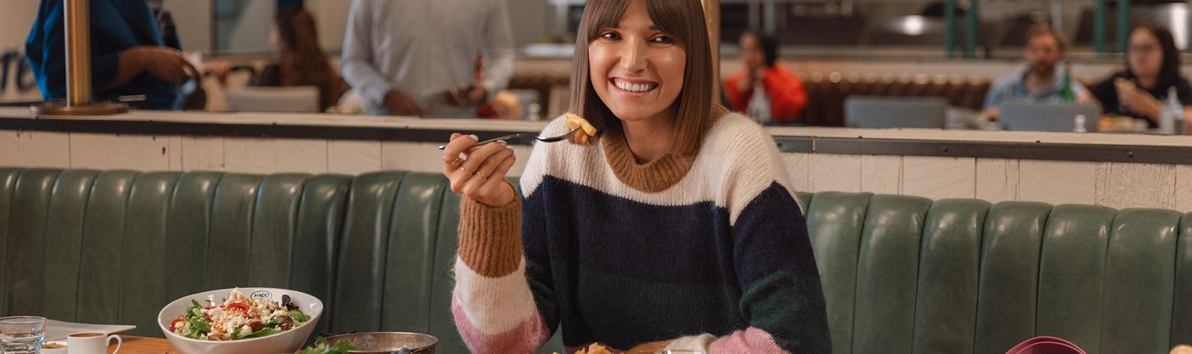Woman dining at a restaurant inside the mall enjoying a relaxed and casual dining experience