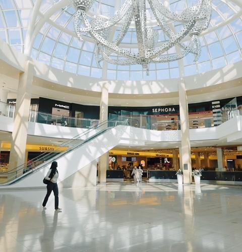 Shopping centre interior featuring escalators and retail stores including Sephora