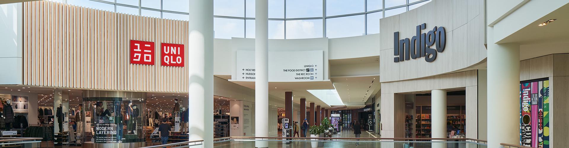 Retail corridor featuring Uniqlo and Indigo storefronts with clearly visible directory signage