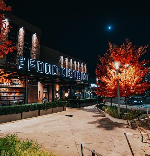 Food district lit at night with restaurants offering a vibrant and lively dining atmosphere