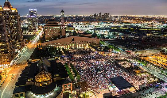 Public square filled with a large crowd gathering for events, celebrations, and concerts at night