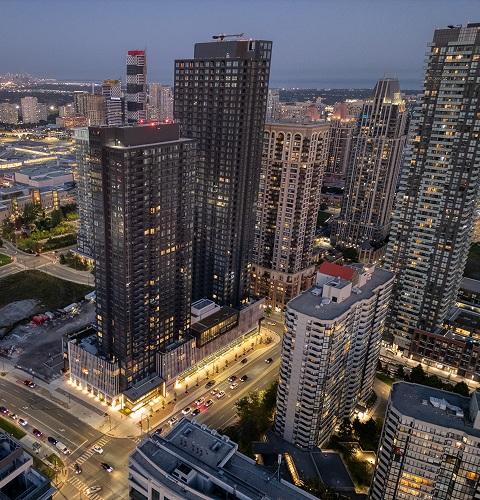 Aerial view of a busy shopping district with modern buildings and vibrant city streets lit at night