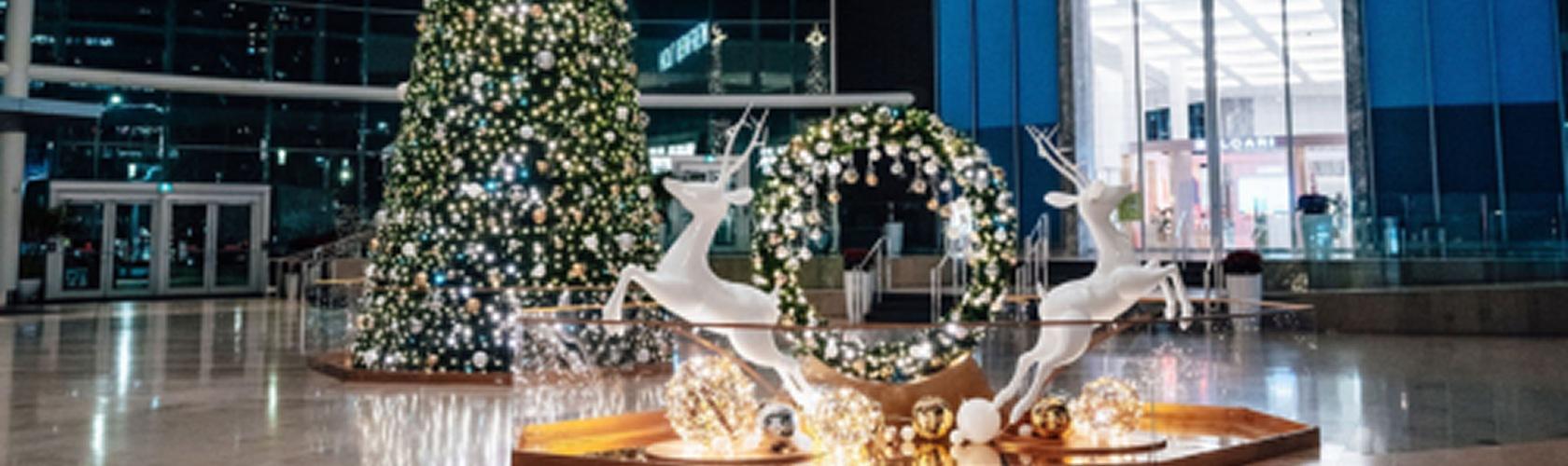 Holiday sponsorship display at a mall with festive decor and a decorated Christmas tree